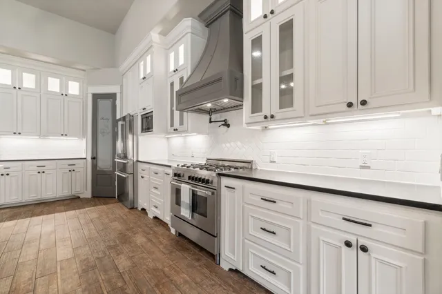 a kitchen with stainless steel appliances granite countertop a sink a stove and a refrigerator