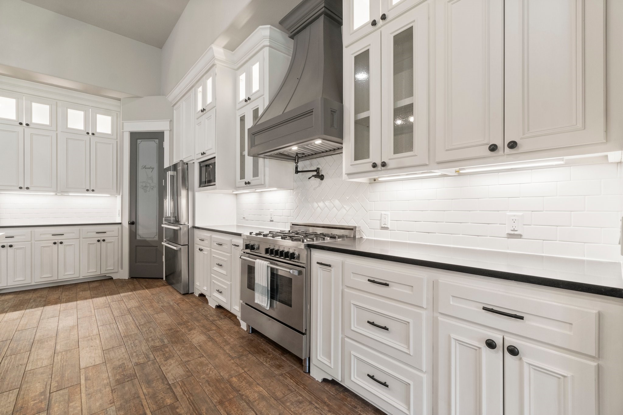 2402 Chantilly Lane Conroe, TX 77384 - Photo 11 of 49 a kitchen with stainless steel appliances granite countertop a sink a stove and a refrigerator