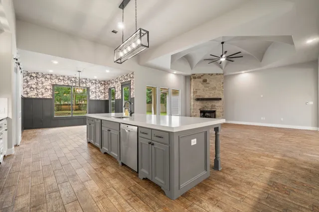 a large kitchen with stainless steel appliances granite countertop a large counter top and white cabinets