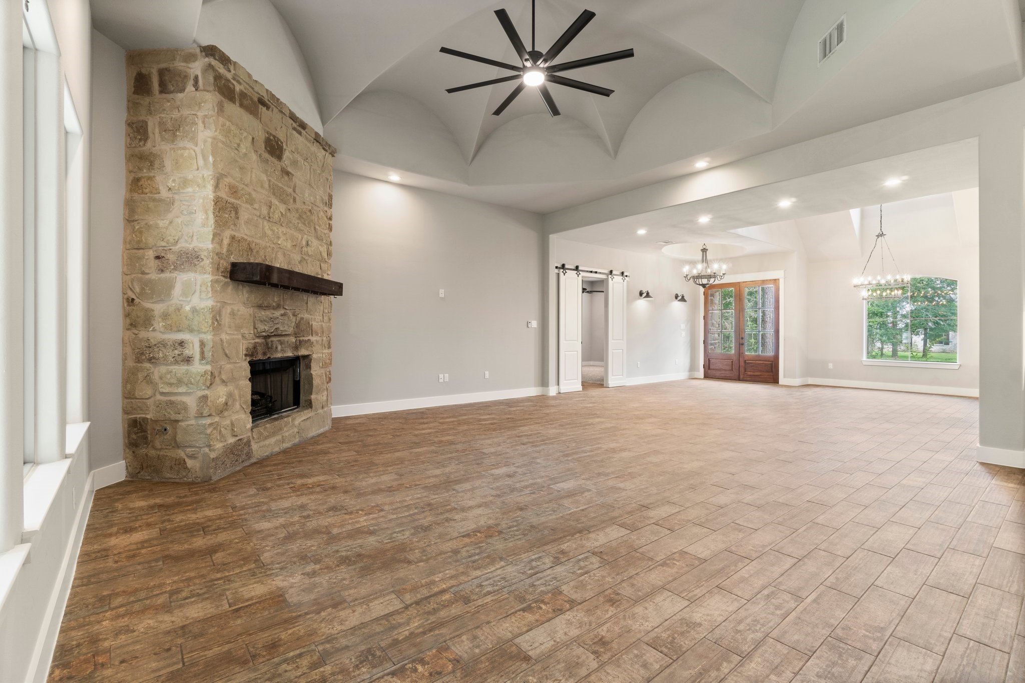 2402 Chantilly Lane Conroe, TX 77384 - Photo 15 of 49 a view of a livingroom with a fireplace a ceiling fan and windows