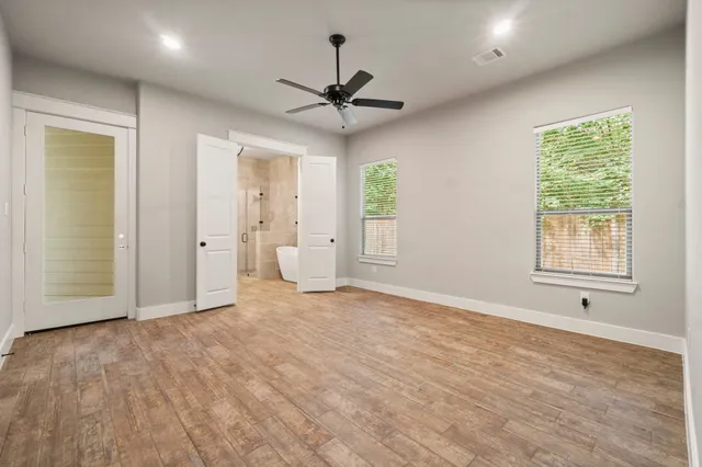 an empty room with fan and windows