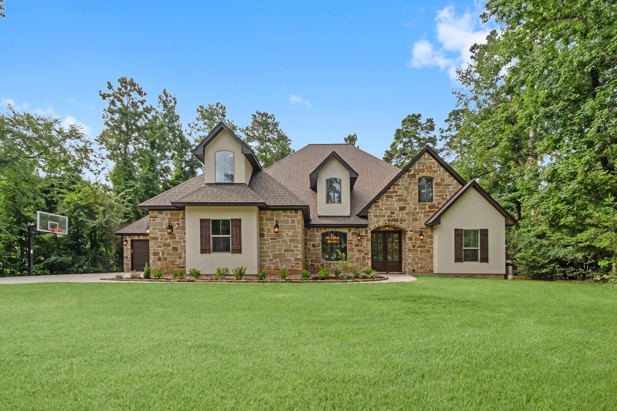 2402 Chantilly Lane Conroe, TX 77384 - Photo 2 of 49 a front view of a house with a garden