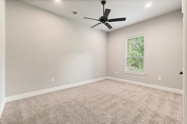 a view of a livingroom with a ceiling fan and window