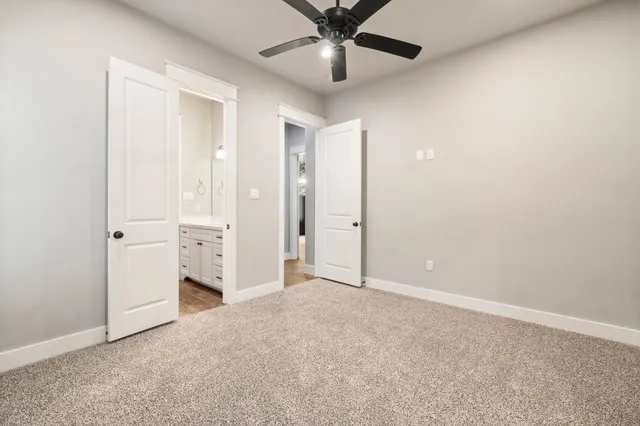 an empty room with closet and a ceiling fan