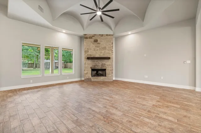 a view of an empty room with a fireplace and a window