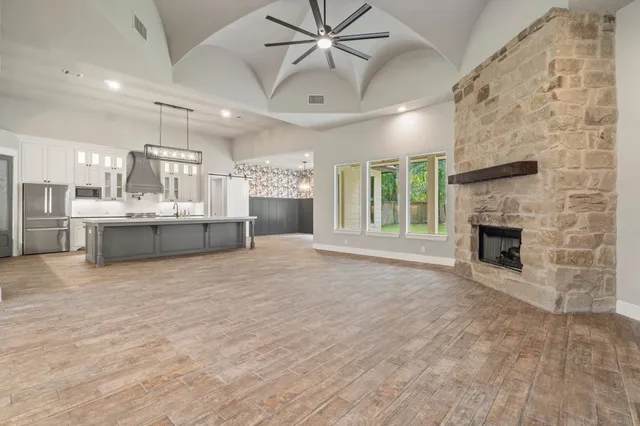 a view of a livingroom with a fireplace and chandelier fan