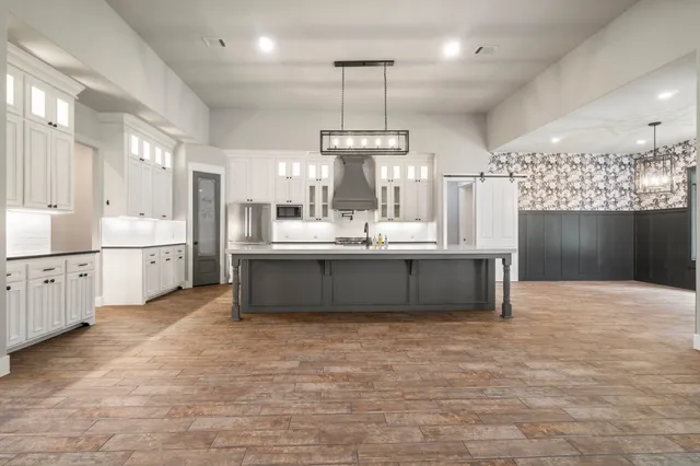 a large kitchen with kitchen island a sink stainless steel appliances and cabinets