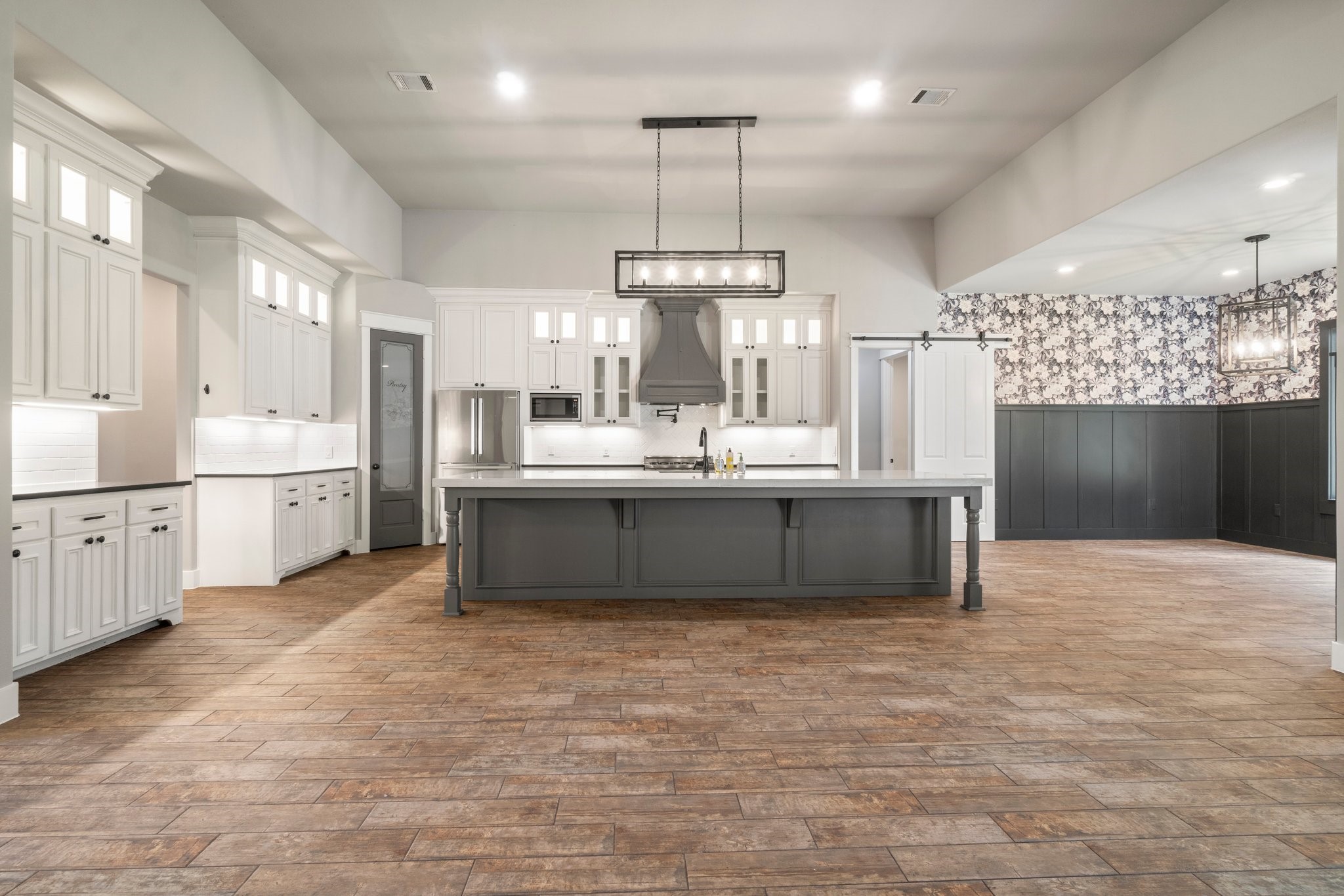 2402 Chantilly Lane Conroe, TX 77384 - Photo 9 of 49 a large kitchen with kitchen island a sink stainless steel appliances and cabinets