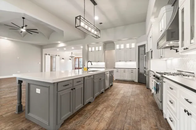 a large kitchen with a stove and cabinets