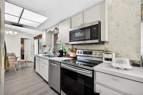 a kitchen with stainless steel appliances a stove microwave and sink
