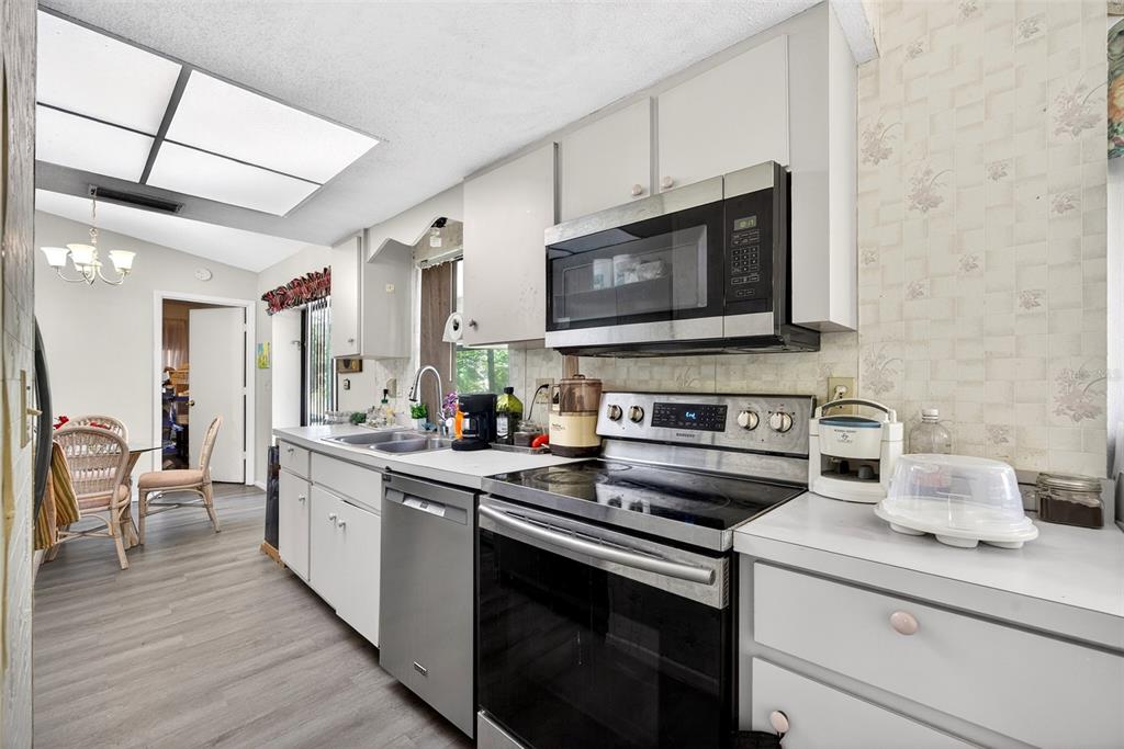 464 Coronado Road Venice, FL 34293 - Photo 9 of 28 a kitchen with stainless steel appliances a stove microwave and sink