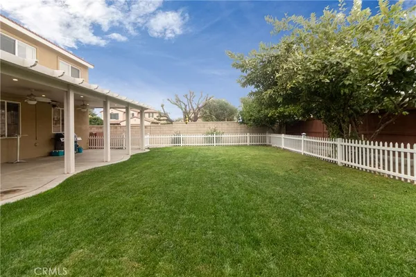 a view of a house with a big yard and large tree