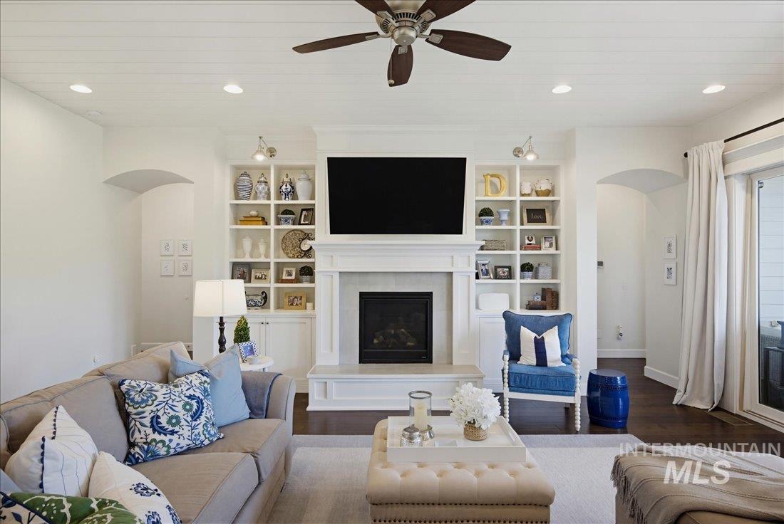 939 South Lake Pointe Way Eagle, ID 83616 - Photo 14 of 50 Living area featuring a fireplace with a mantel, built-in shelving, a ceiling fan, recessed lighting, and dark wood-finish flooring