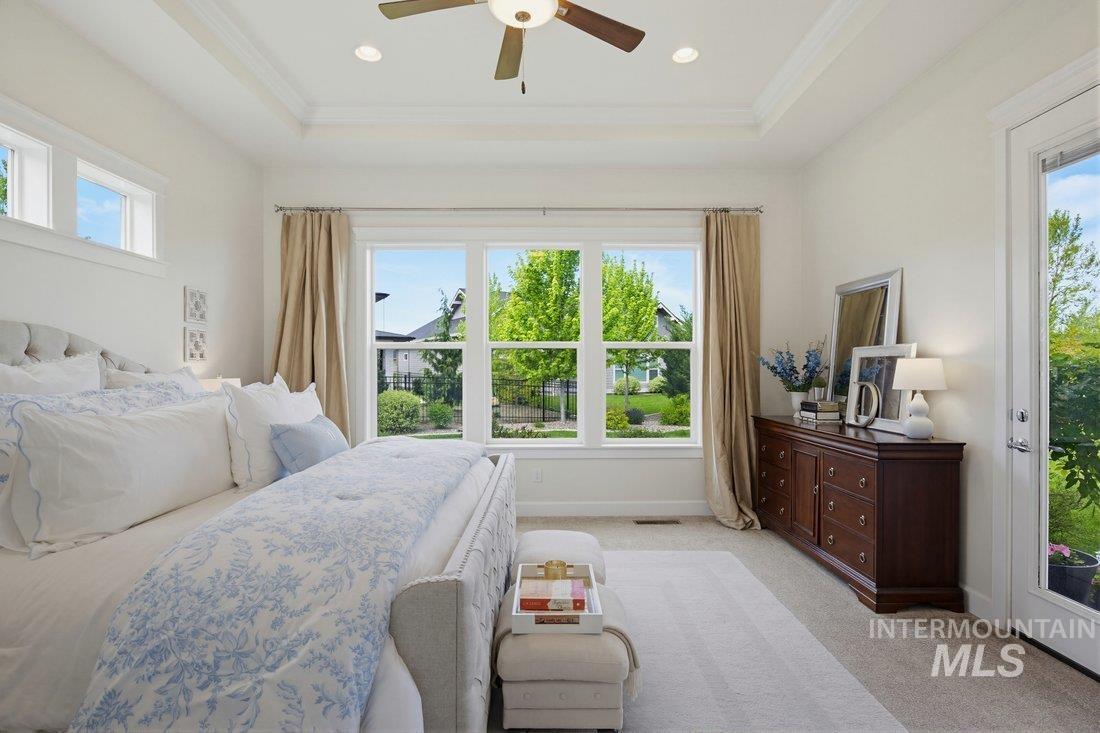 939 South Lake Pointe Way Eagle, ID 83616 - Photo 19 of 50 Bright bedroom featuring large windows, a tray ceiling with recessed lighting, a ceiling fan, and carpeted flooring