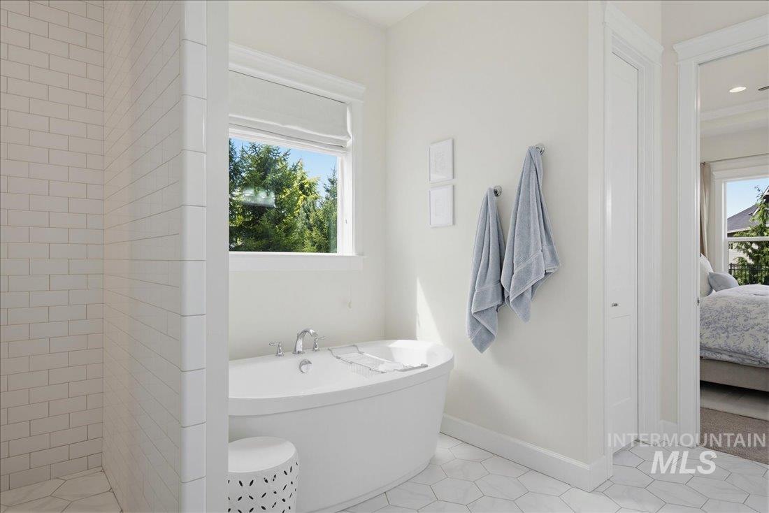 939 South Lake Pointe Way Eagle, ID 83616 - Photo 20 of 50 Freestanding soaking tub with chrome fixtures, set against a window with outdoor greenery