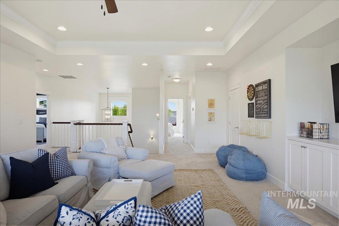 939 South Lake Pointe Way Eagle, ID 83616 - Photo 23 of 50 Open concept upper-level space featuring a tray ceiling with recessed lighting, carpet flooring, a built-in white cabinet unit with a countertop, and a white baluster railing