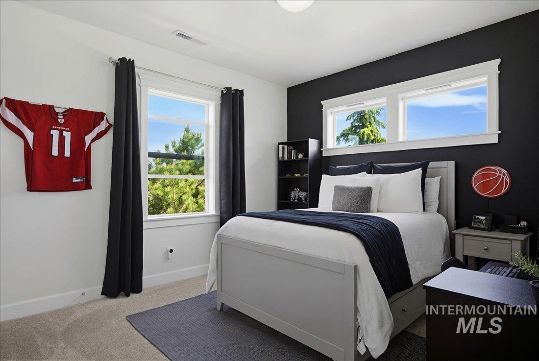939 South Lake Pointe Way Eagle, ID 83616 - Photo 28 of 50 Spacious bedroom featuring light-colored carpeting, multiple windows providing natural illumination, and a contrasting accent wall