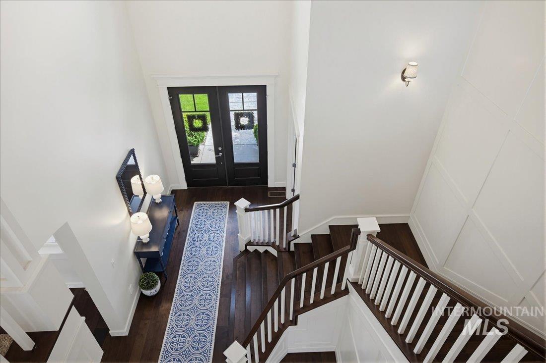 939 South Lake Pointe Way Eagle, ID 83616 - Photo 31 of 50 Two-story foyer with dark wood-finish flooring, a grand staircase with white risers and dark wood handrails, and a modern wall sconce