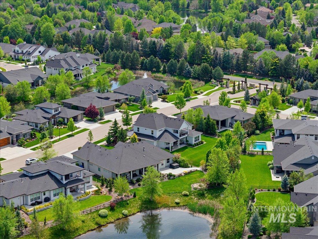 939 South Lake Pointe Way Eagle, ID 83616 - Photo 34 of 50 Aerial view of a residential community featuring multiple homes with dark shingle roofs, manicured lawns, and mature trees
