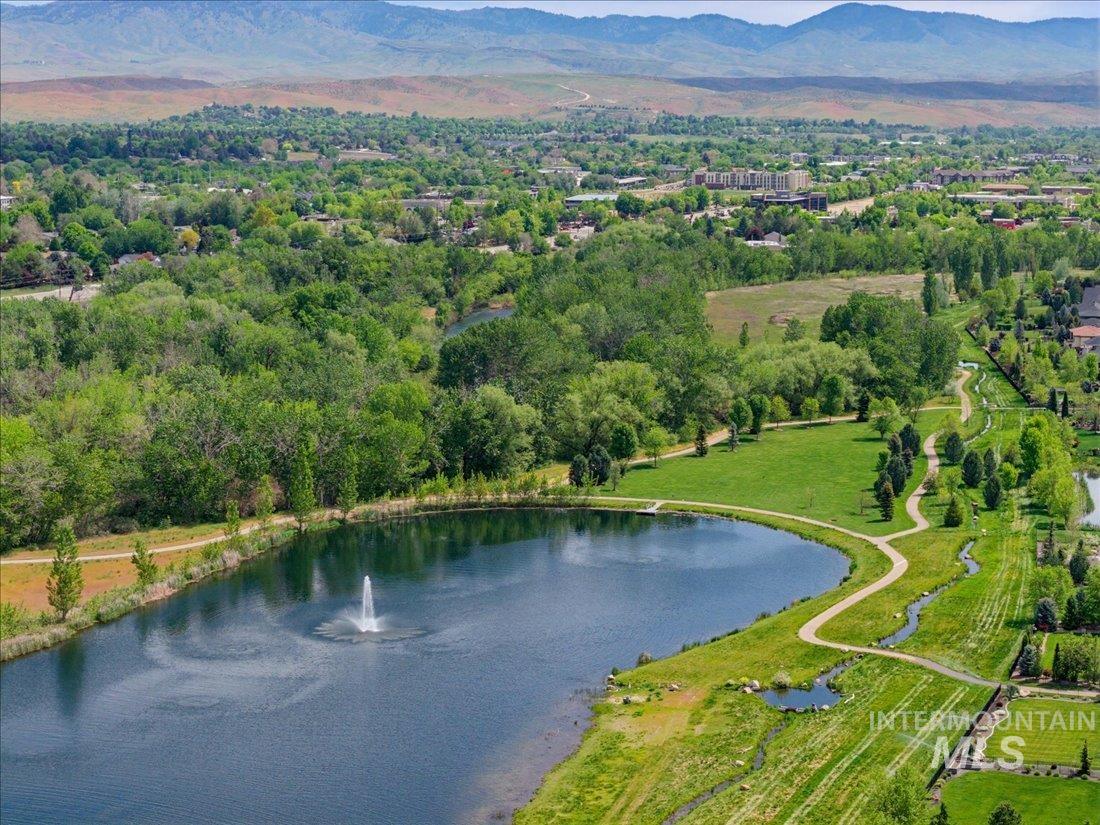 939 South Lake Pointe Way Eagle, ID 83616 - Photo 48 of 50 Expansive parkland featuring a serene pond with a central fountain, winding paved pathways, mature trees, and manicured green spaces