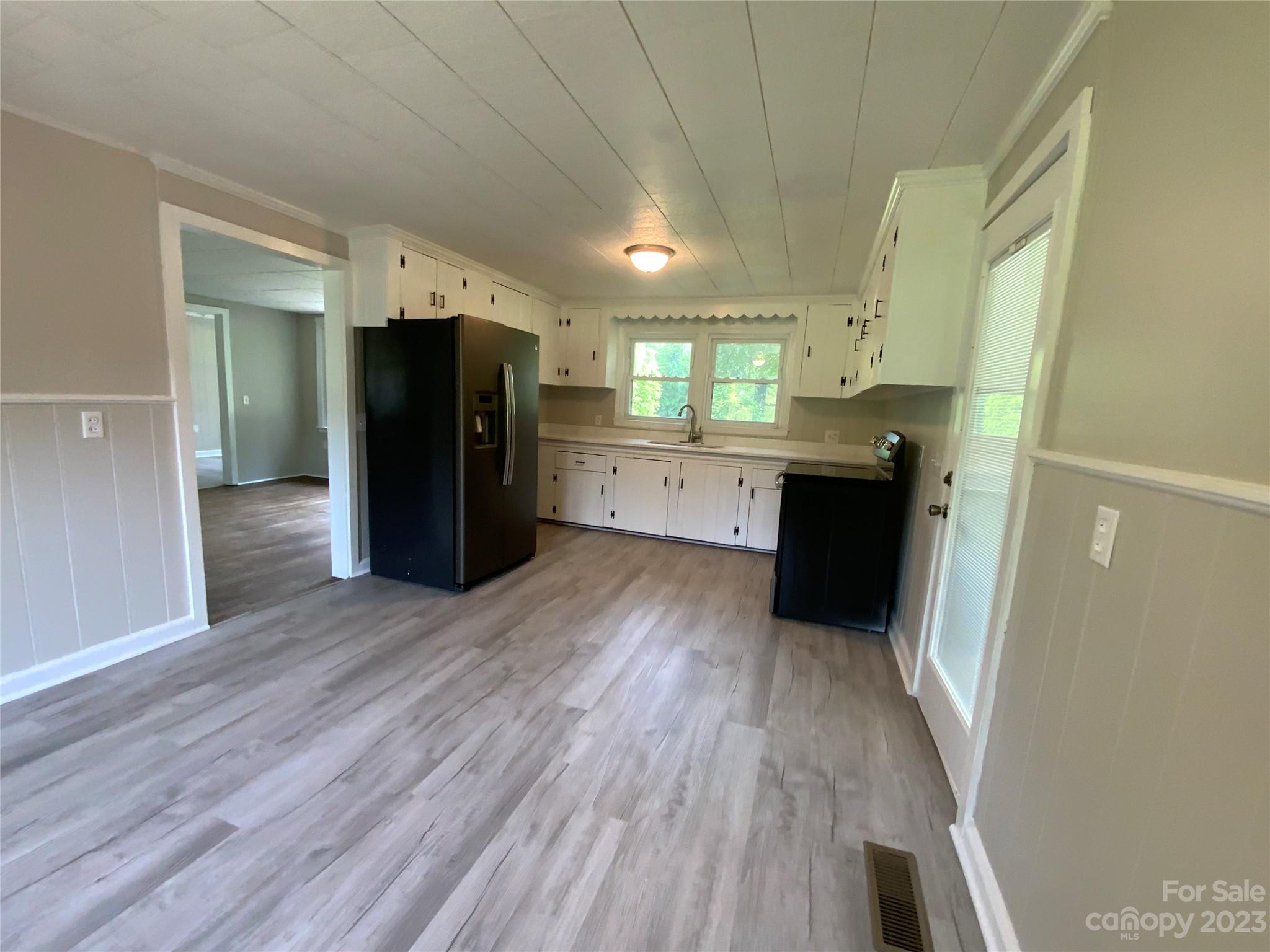 214 Bostic Yard Road Bostic, NC 28018 - Photo 7 of 31 a kitchen with a refrigerator and wooden floor