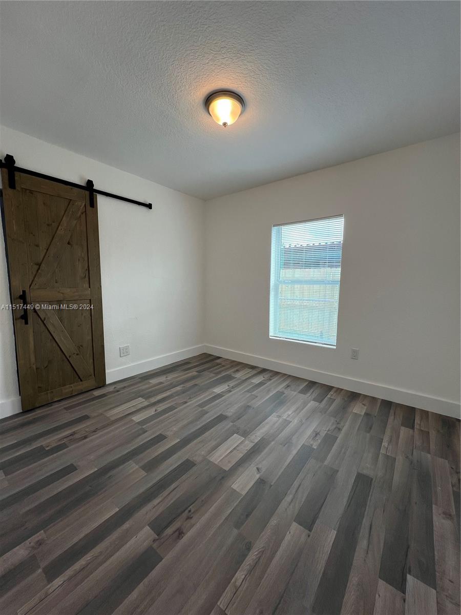 375 West 37th Street Hialeah, FL 33012 - Photo 12 of 19 an empty room with wooden floor and windows