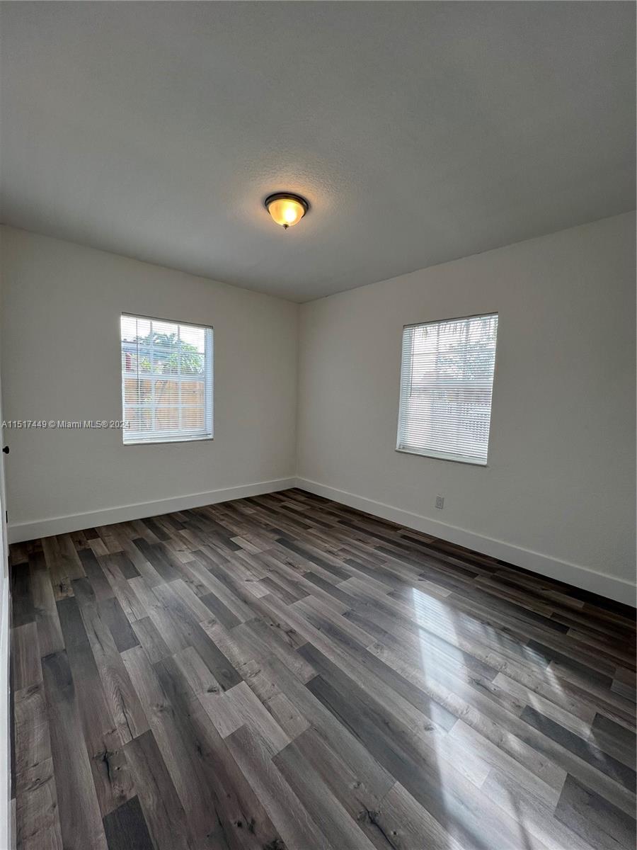 375 West 37th Street Hialeah, FL 33012 - Photo 16 of 19 an empty room with wooden floor and windows