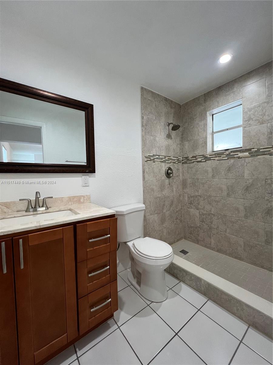 375 West 37th Street Hialeah, FL 33012 - Photo 18 of 19 a bathroom with a toilet a sink a mirror a vanity and shower