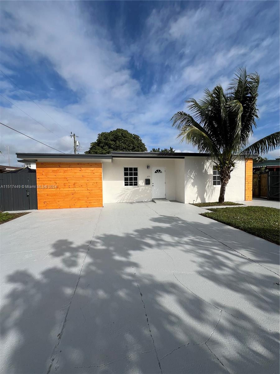 375 West 37th Street Hialeah, FL 33012 - Photo 4 of 19 a view of a house with a yard and a garage
