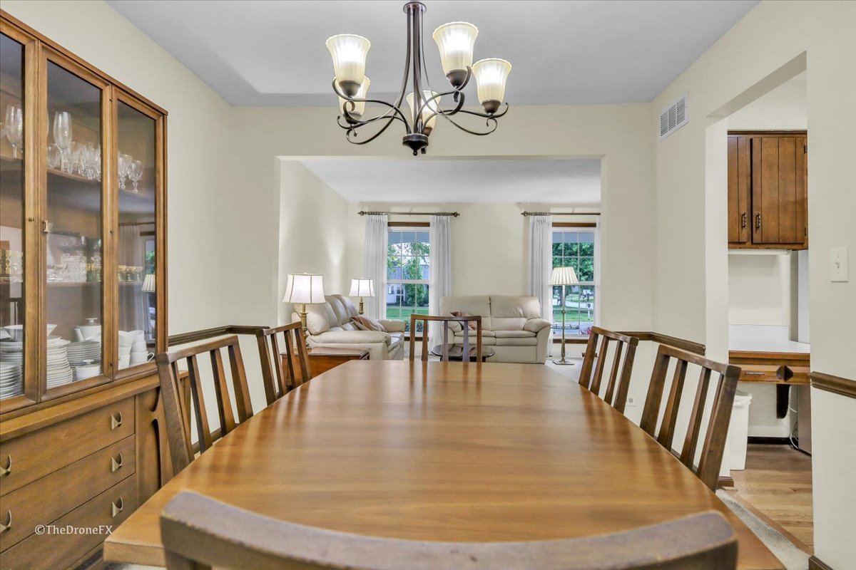 659 Brighton Drive Wheaton, IL 60189 - Photo 18 of 25 a view of a dining room with furniture a chandelier and wooden floor