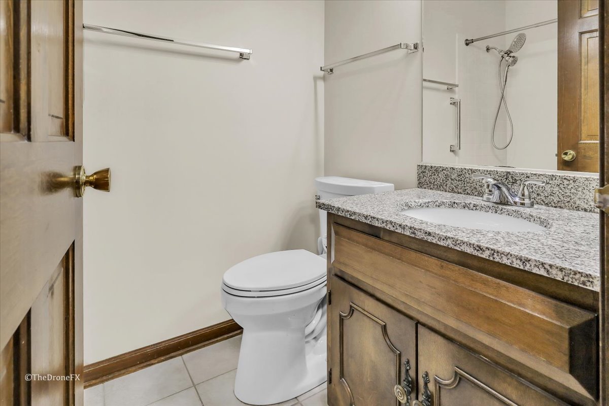 659 Brighton Drive Wheaton, IL 60189 - Photo 24 of 25 a bathroom with a granite countertop sink toilet and shower