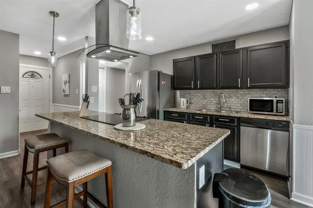 a kitchen with a sink a stove a refrigerator and cabinets