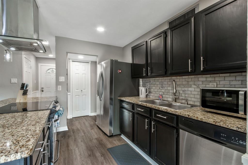 5652 Phelps Street The Colony, TX 75056 - Photo 15 of 29 a kitchen with stainless steel appliances granite countertop a refrigerator a stove and a microwave oven with wooden floor