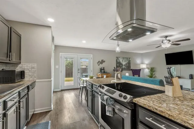 a kitchen with stainless steel appliances granite countertop a sink stove and refrigerator