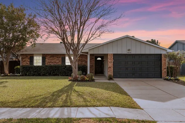 a front view of a house with yard and garage