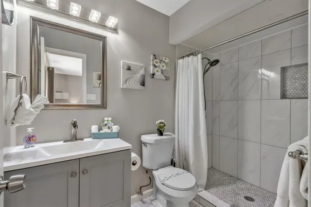 a bathroom with a sink a toilet and shower