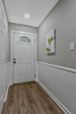an empty room with a hallway and wooden floor