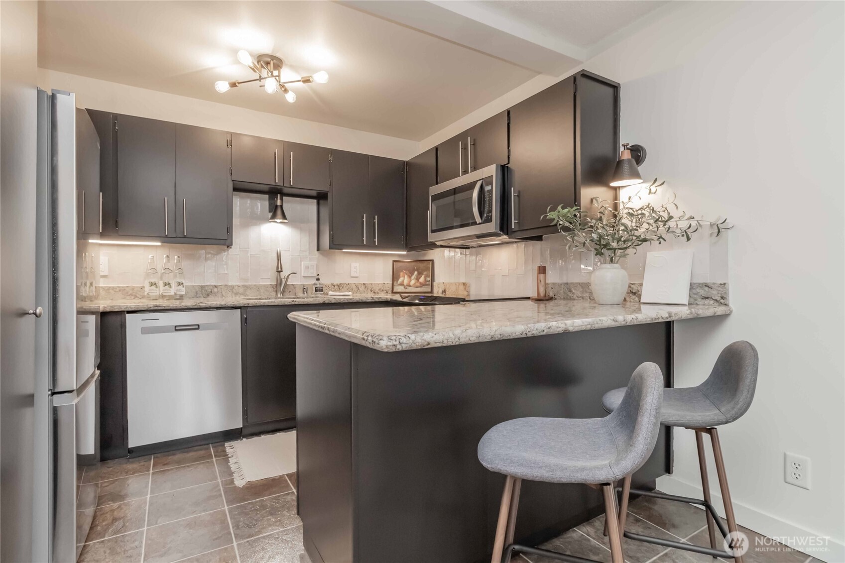 1425 South Puget Drive, Unit O4 Renton, WA 98055 - Photo 17 of 32 a kitchen with kitchen island granite countertop a sink cabinets and refrigerator