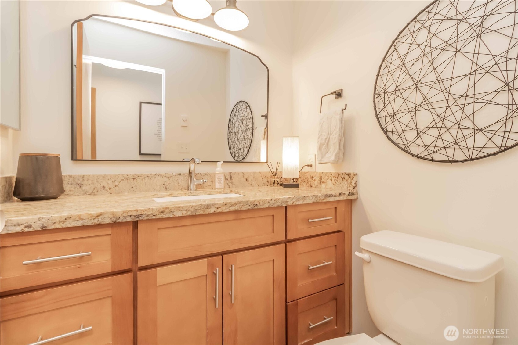 1425 South Puget Drive, Unit O4 Renton, WA 98055 - Photo 22 of 32 a bathroom with a granite countertop toilet sink and mirror