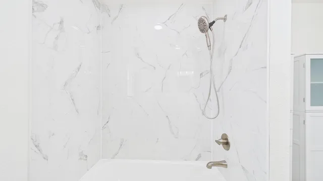 a bathroom with a bath tub with a shower