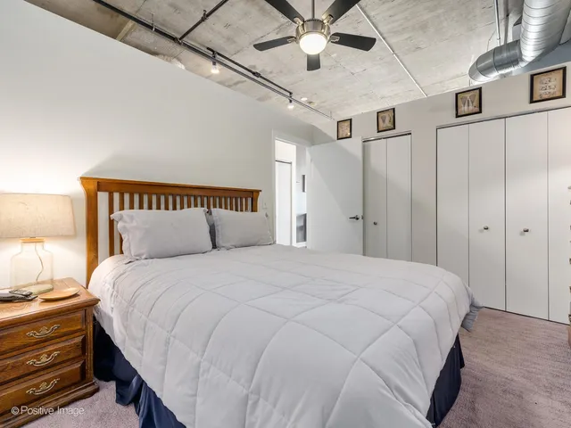 a large bed sitting in a bedroom next to a lamp