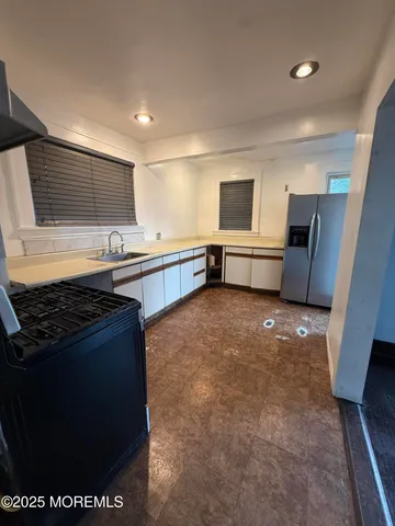 a kitchen with stainless steel appliances granite countertop a sink stove and cabinets