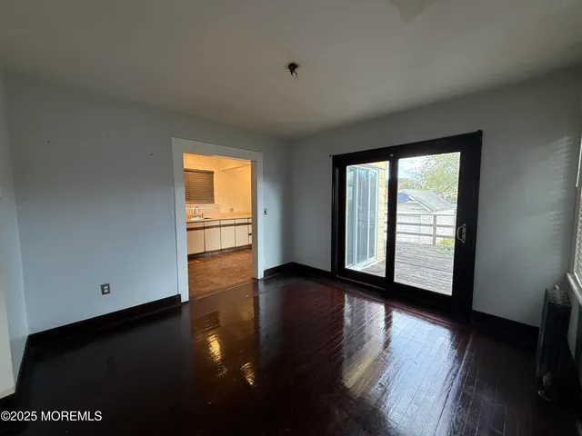 a view of a room with wooden floor and a window