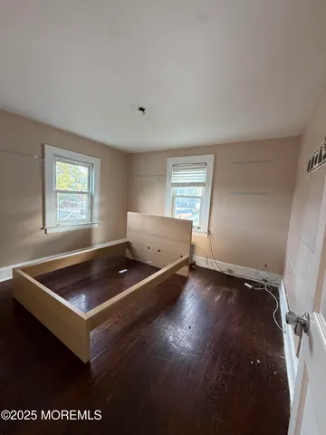 a living room with hard wood floors and window