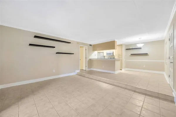 an empty room with wooden floor chandelier fan and windows