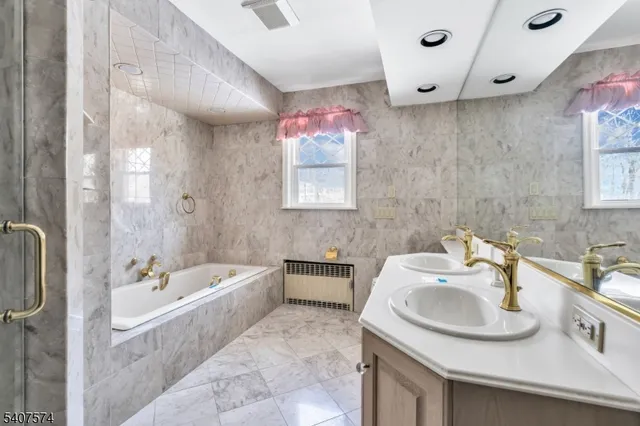 a bathroom with a tub sink and mirror