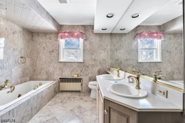 a bathroom with a bath tub a sink and mirror