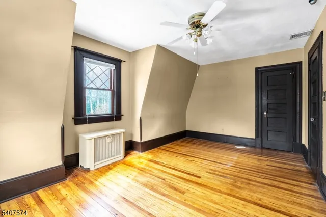 a view of empty room with window and a ceiling fan