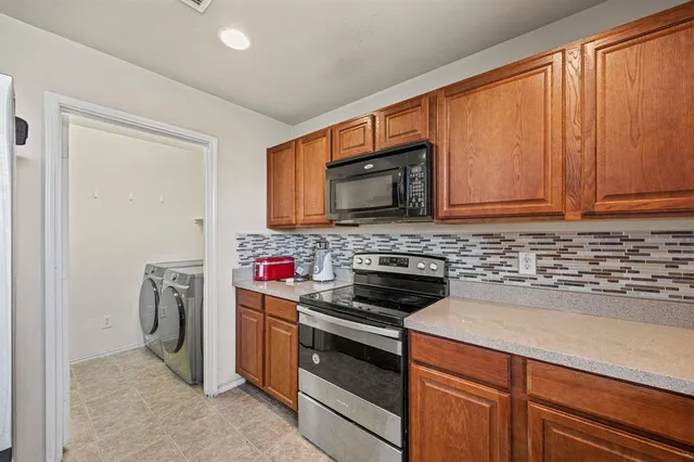 a kitchen with stainless steel appliances a stove microwave and sink