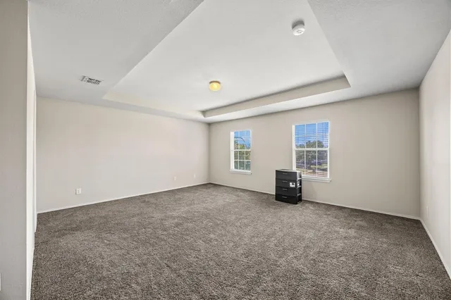 an empty room with white walls and windows